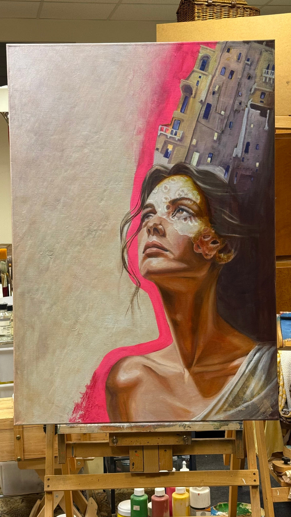 Painting of a woman with abstract elements on an easel in a studio setting