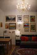 Collector living room gallery wall featuring original paintings Red Regatta and View from the Slovak Ministry of Culture by Zuzana Kochanková
