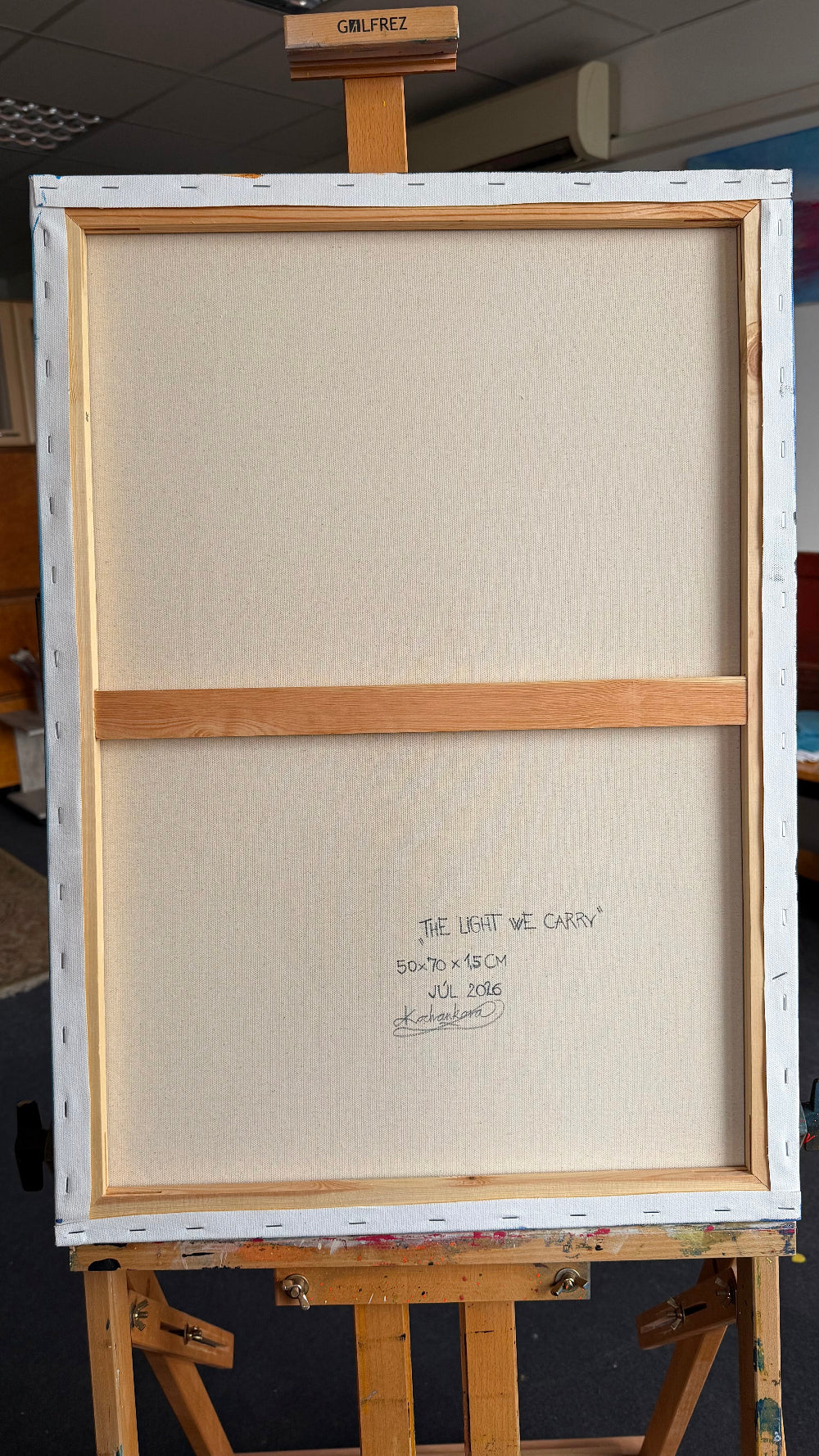 Canvas
Back view of The Light We Carry showing the stretched canvas, wooden stretcher frame and artist information.