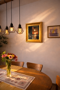 Venice canal painting “Venetian Night” displayed in a warm minimalist dining interior with wooden table, soft evening light, and modern pendant lamps