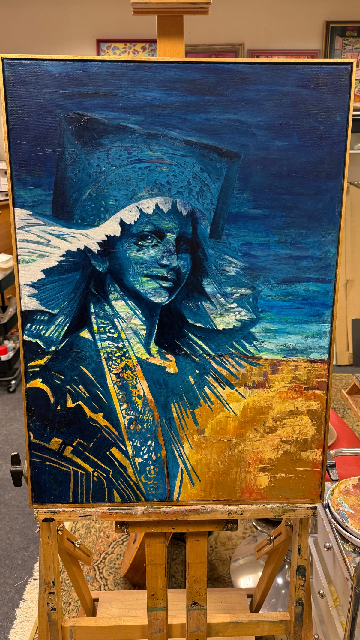 Artistic depiction of a character in a blue and gold costume on an easel.